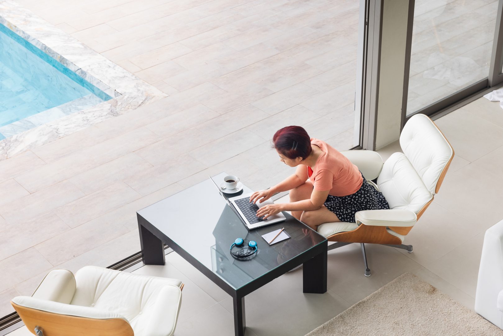ผู้หญิงนั่งทำงานที่บ้านสไตล์พูลวิลล่า หัวหิน เพื่อเปลี่ยนบรรยากาศ
